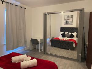 a bedroom with a mirror and a bed and a desk at SAV 3 Bedroom House Chiltern Rise Luton in Luton