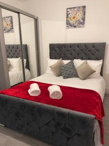 - une chambre dotée d'un grand lit avec deux chapeaux dans l'établissement SAV 3 Bedroom House Chiltern Rise Luton, à Luton