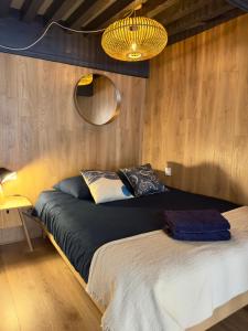 a bedroom with a bed and a mirror and lights at Le Bucolique - Cœur Vieille-ville d'Annecy in Annecy