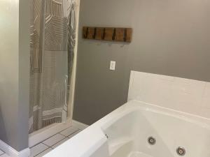 a white bath tub with a shower in a bathroom at Home just outside of Hendersonville in Hendersonville