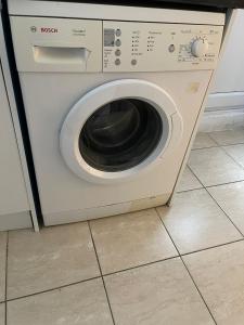 a washing machine sitting on a tiled floor at SAV 3 Bedroom House Chiltern Rise Luton in Luton