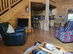 a living room with a couch and a tv in a cabin at The perfect hideaway just outside of Algood and minutes to Cookeville!!! in Cookeville