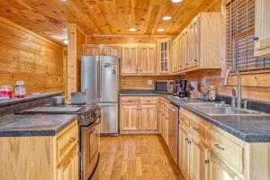 uma cozinha com armários de madeira e um frigorífico de aço inoxidável em The perfect hideaway just outside of Algood and minutes to Cookeville!!! em Cookeville