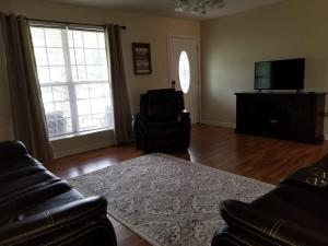a living room with a couch and a television at Spacious 3BR 2BA 11 mins away from Cummins Falls State Park!!! in Cookeville