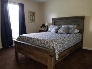 a bedroom with a wooden bed with pillows and a window at Spacious 3BR 2BA 11 mins away from Cummins Falls State Park!!! in Cookeville