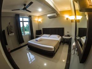 a hotel room with a bed and a window at Najmi Inn Hotel in Kampong Burok