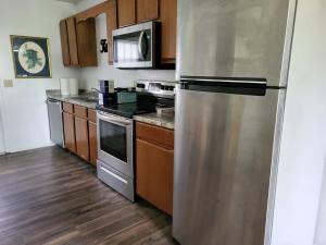 una cocina con nevera de acero inoxidable y armarios de madera en Welcome Home to this 2 bedroom 1 bath apartment near TTU, en Cookeville