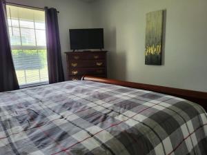 1 dormitorio con 1 cama y vestidor con TV en Welcome Home to this 2 bedroom 1 bath apartment near TTU, en Cookeville