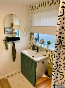 謝菲爾德的住宿－K Suites - Park Grange Croft，浴室设有绿色和白色的盥洗盆和窗户。