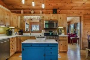 una cocina con armarios de madera y una isla azul en Pigeon Ridge Cabin Cumberland State Park 2B 2B, en Crossville