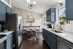 a kitchen with blue cabinets and a table with chairs at Burgess Falls bungalow minutes from Cookeville in Sparta