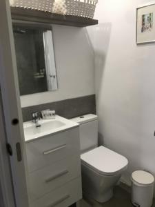 a white bathroom with a toilet and a sink at HAPPYVILA Apartments in Villajoyosa
