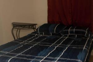 a bed with a blue and white blanket and a table at Less than 1 mile from Fort Sill 2 Bedrooms!!!! in Lawton