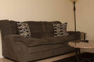 Sofá marrón en la sala de estar con mesa en Less than 1 mile from Fort Sill 2 Bedrooms!!!!, en Lawton