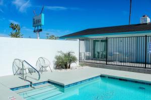 una piscina con 2 sillas junto a una casa en Scottsdale - 445 N Arizona Ave Unit 13 en Chandler