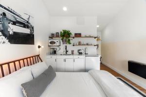 Sala de estar blanca con cama y cocina en Scottsdale - 445 N Arizona Ave Unit 13 en Chandler