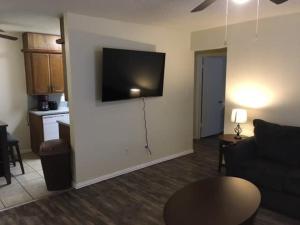 a living room with a couch and a television on a wall at Simple 1-bedroom unit upstairs close to Fort Sill! in Lawton