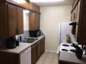 cocina con fregadero y nevera blanca en Simple 1-bedroom unit upstairs close to Fort Sill!, en Lawton