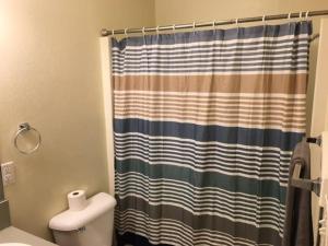 a bathroom with a shower curtain and a toilet at Simple 1-bedroom unit upstairs close to Fort Sill! in Lawton