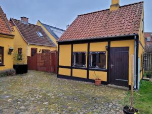 een geel en zwart huis met een hek bij Oasen Holbæk Centrum in Holbæk