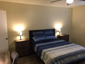 a bedroom with a bed with two night stands and two lamps at Simple 1-bedroom unit upstairs close to Fort Sill! in Lawton