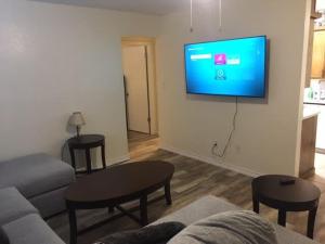 ein Wohnzimmer mit einem Sofa und einem TV an der Wand in der Unterkunft Close to Fort Sill Upstairs 1 bedroom apartment in Lawton