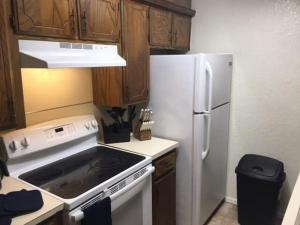 uma cozinha com um frigorífico branco e armários de madeira em Close to Fort Sill Upstairs 1 bedroom apartment em Lawton