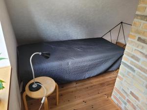 Cama en habitación con lámpara y silla en Oasen Holbæk Centrum, en Holbæk