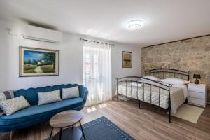 a living room with a blue couch and a bed at Holiday Home Riva Promenade in Split