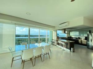 cocina y comedor con mesa y sillas en Departamento frente al mar, en Cancún