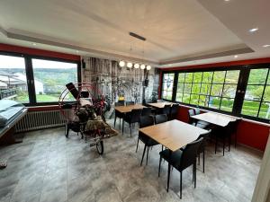 a restaurant with tables and chairs and windows at obermaubach-am see Apartments in Kreuzau