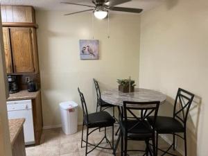 - une table et des chaises dans une cuisine avec un ventilateur de plafond dans l'établissement Charming 1-BR upstairs apartment near Fort Sill!, à Lawton