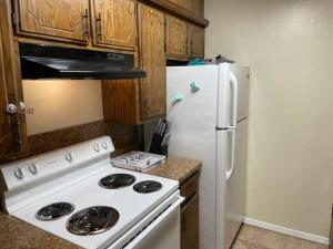 Il comprend une cuisine équipée d'une cuisinière et d'un réfrigérateur blancs. dans l'établissement Charming 1-BR upstairs apartment near Fort Sill!, à Lawton