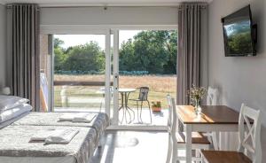 a bedroom with a bed and a table and a dining room at Bornholm Apartments in Svaneke
