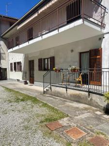 a white building with a balcony and a porch at Appartamento Gaia - a due passi dal centro in Laveno-Mombello