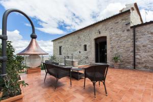 a patio with a table and chairs and a bell at A Casa Nostra Residenza di Charme - Struttura sanificata giornalmente con ozono in Candela