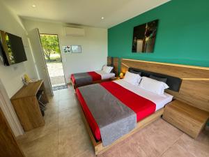 a bedroom with two beds and a green wall at DOMAINE MAXXIM in Clermont-lʼHérault