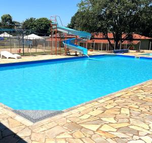 una gran piscina con un tobogán azul. en Ananda pousada chalé en São Pedro