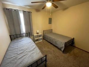 1 dormitorio con 2 camas y ventilador de techo en 2BR 1Bath Downstairs Apartment near Fort Sill, en Lawton