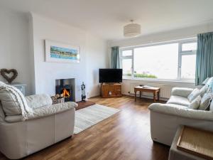 a living room with two couches and a fireplace at Bryn Eithin in Benllech