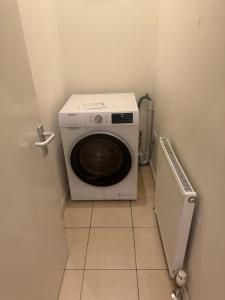 een wasmachine en droger in een kleine kamer bij HANDOVER 3 in Londen