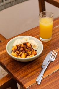 une assiette de nourriture avec des bananes et un verre de jus d'orange dans l'établissement Casa Peregrino Holbox, à Holbox