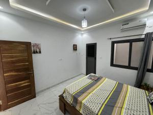um quarto com uma cama e uma porta de madeira em Résidences Salsia - Almadies - Studio RDC em Dakar