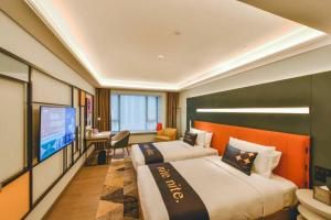 Habitación de hotel con 2 camas y TV de pantalla plana. en MUSTEL Hotel Guangzhou Nansha, en Guangzhou