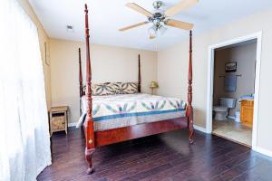 a bedroom with a canopy bed and a ceiling fan at Cozy, comfortable Pigeon Forge home close to all attractions and beautiful river in Pigeon Forge