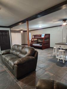 a living room with a leather couch and a bed at Cozy, comfortable Pigeon Forge home close to all attractions and beautiful river in Pigeon Forge
