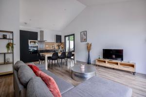 - un salon avec un canapé et une table dans l'établissement Maison T4 Climatisée avec Jacuzzi à Lagord, à Lagord