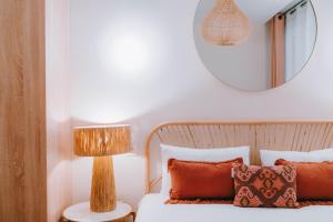 ein Schlafzimmer mit einem Bett mit einer Lampe und einem Spiegel in der Unterkunft Apparts' Rennes BnB Solferino -Centre Gare in Rennes