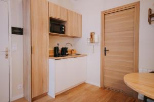 a small kitchen with a microwave and a door at Apparts' Rennes BnB Solferino -Centre Gare in Rennes