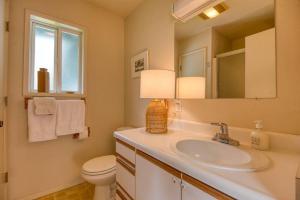 a bathroom with a sink and a toilet and a mirror at #StayinMyDistrict Cape Arago Ocean Studio Suite in Coos Bay